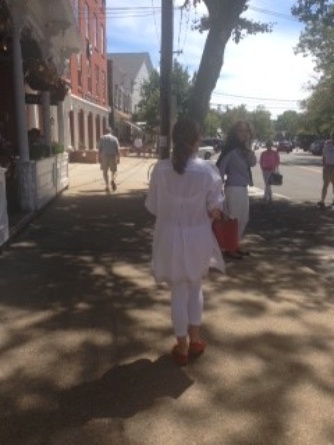 Accessorizing white with red. She is also rocking a visible bra. It happens with white and it works for her