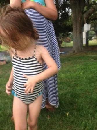 Stripey swimsuit accessorized with a swim diaper and a striped towel