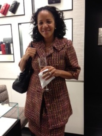 Here’s a classic Chanel look–nubby tweed–on a businesswoman at the event. Note the wallets displayed like framed art in the background.