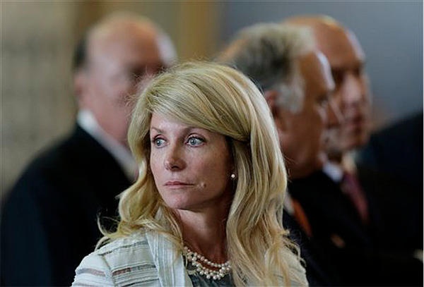 Bi-pedal, semi-continuously sexually receptive female primate and keen maternal strategist Wendy Davis surrounded by high-ranking male primates